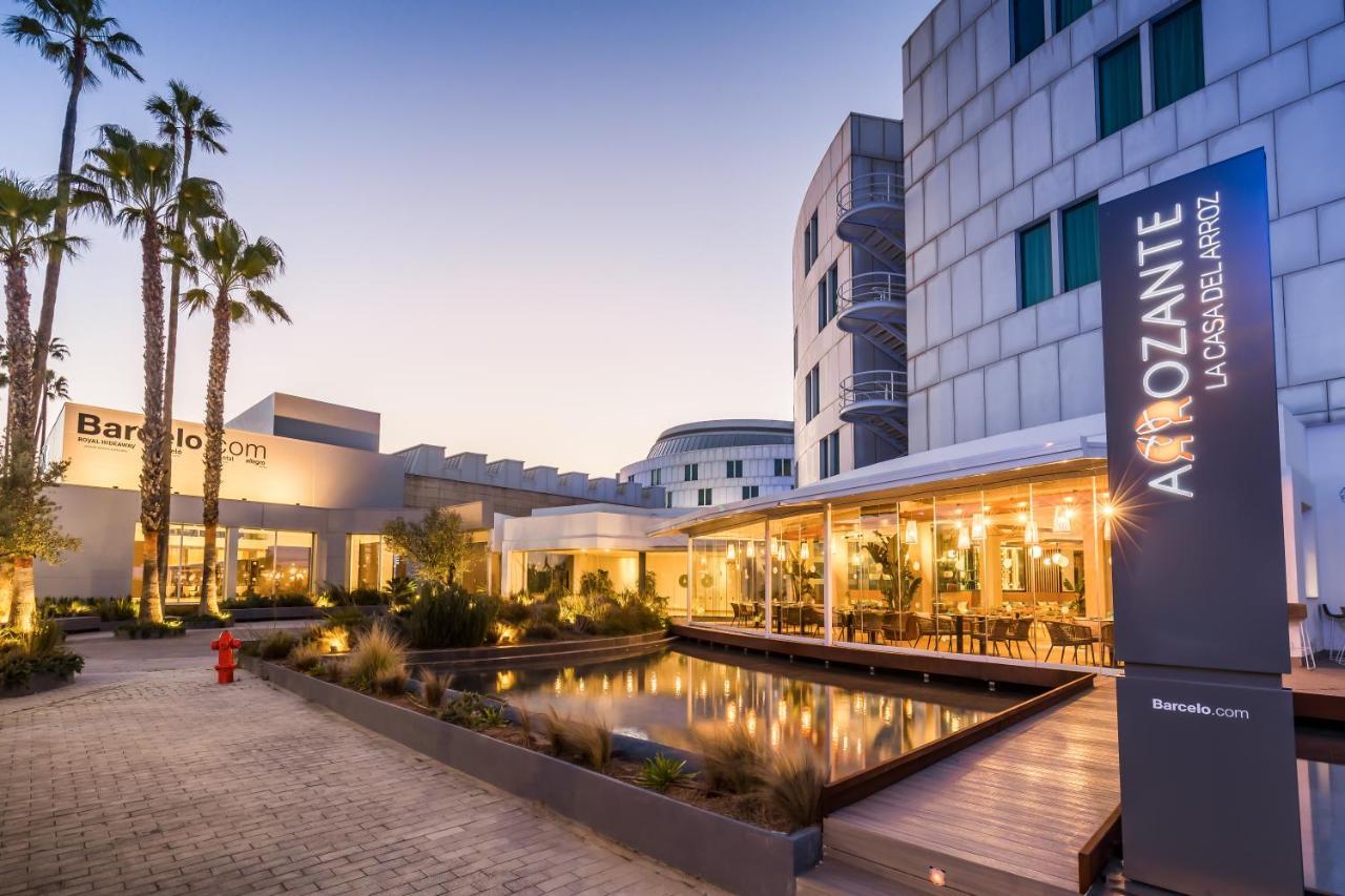 Barcelo Sevilla Renacimiento Esterno foto The photo shows a modern building with a welcoming exterior, typically associated with a hotel or resort. There is a prominent sign displaying "AmoZante," suggesting it may be a dining or entertainment venue. The setting has an outdoor area featuring